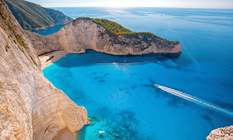 An Ionian Islands yacht charter takes you to quiet beaches with unique rock formations overhanging the sand and water